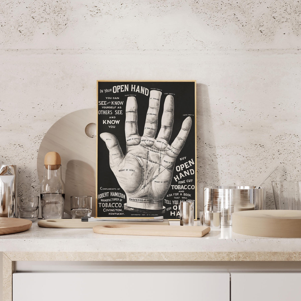 a poster of a hand with various texts and diagrams, displayed on a shelf or counter.