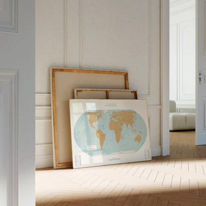 a large world map on a wooden floor, with a white door and a white wall in the background.