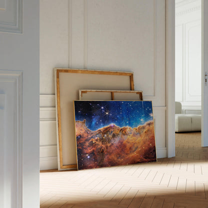 a large, colorful painting of a starry night sky on a wooden floor, with a white door and a white wall in the background.