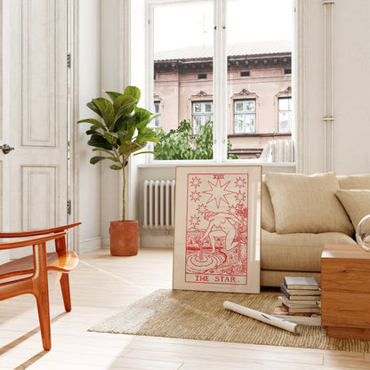a cozy living room with a large window overlooking a building. The room is furnished with a couch, a coffee table, and a potted plant. A large poster or painting of a tarot card, specifically "The Star", is prominently displayed on the wall.